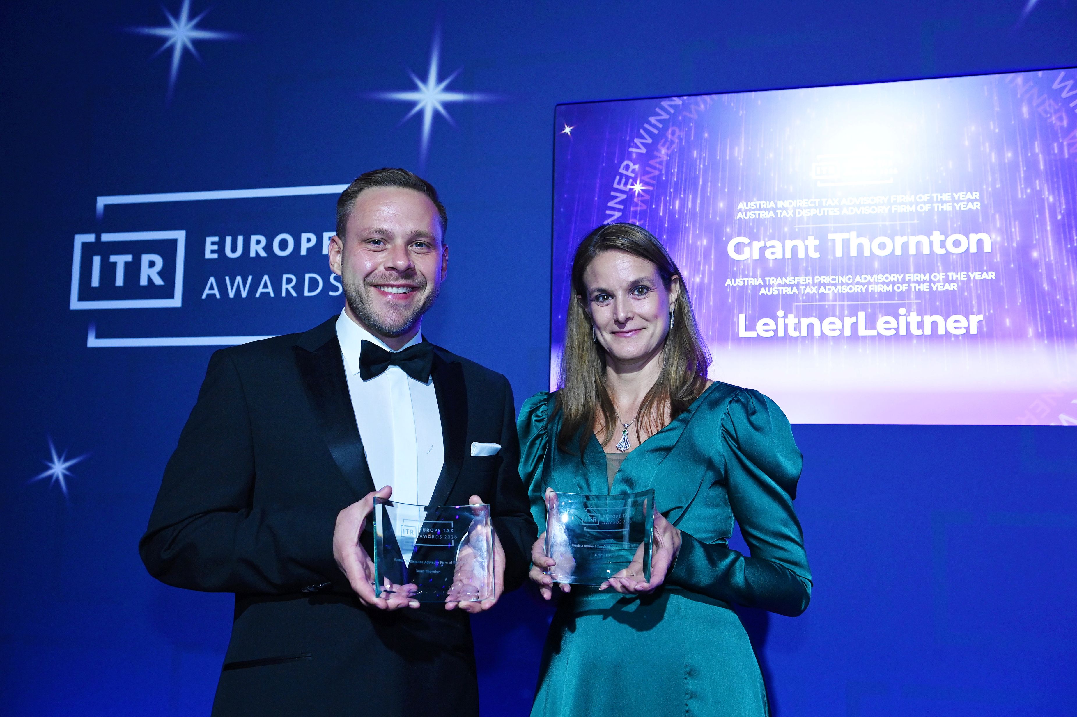 V.l.n.r.: Raphael Holzinger, Partner & Head of Tax, und Claudia Modarressy, Partnerin und Head of Indirect Tax, halten ihre Awards.