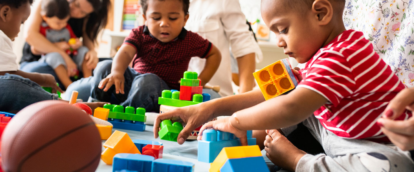 A group of small children playing with building blocks